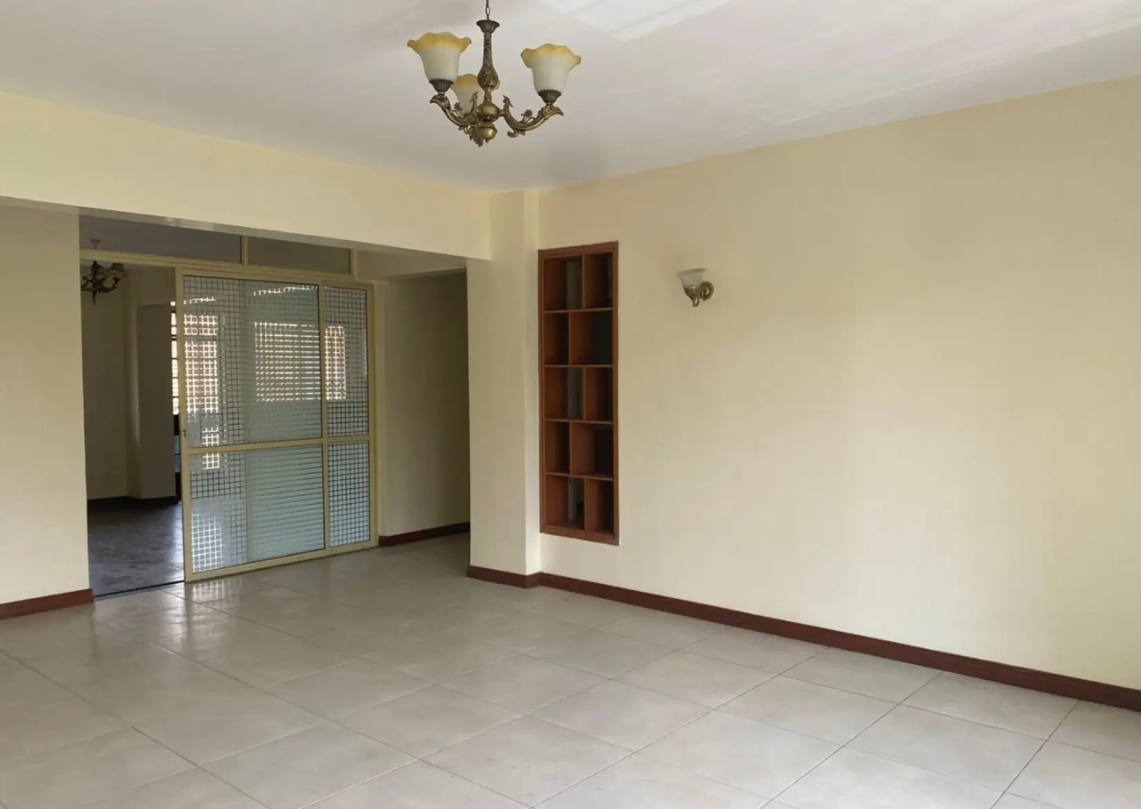 Spacious empty living room with cream walls and tile flooring