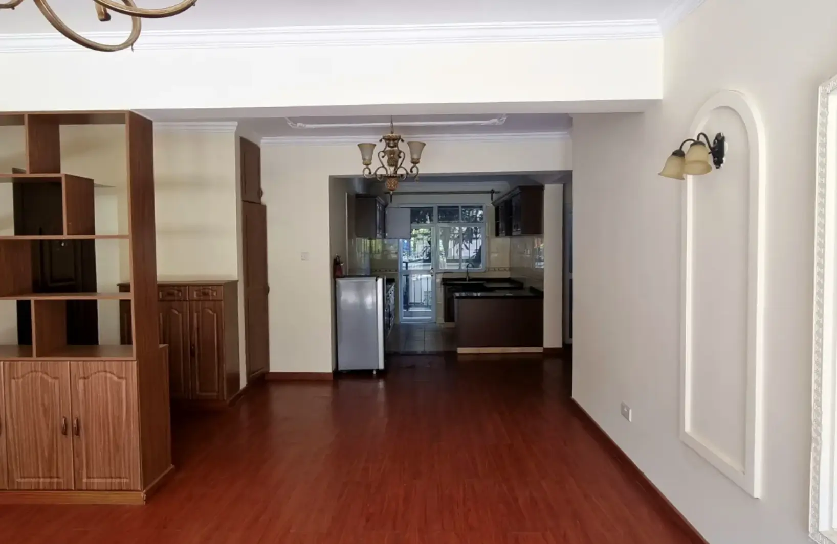 Open-plan living area with wooden storage unit and kitchen access