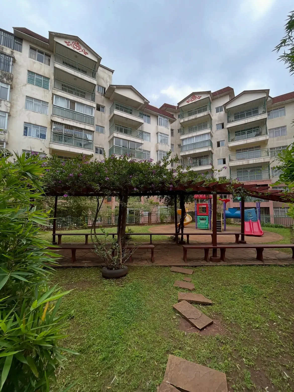 Compound grounds with playground, shaded seating, green lawn