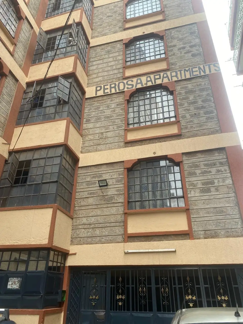 Multi-story residential building facade with brick and cream finish