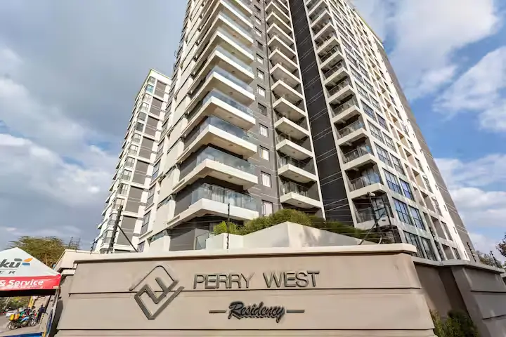 Modern multi-story residential tower with balconies and entrance signage