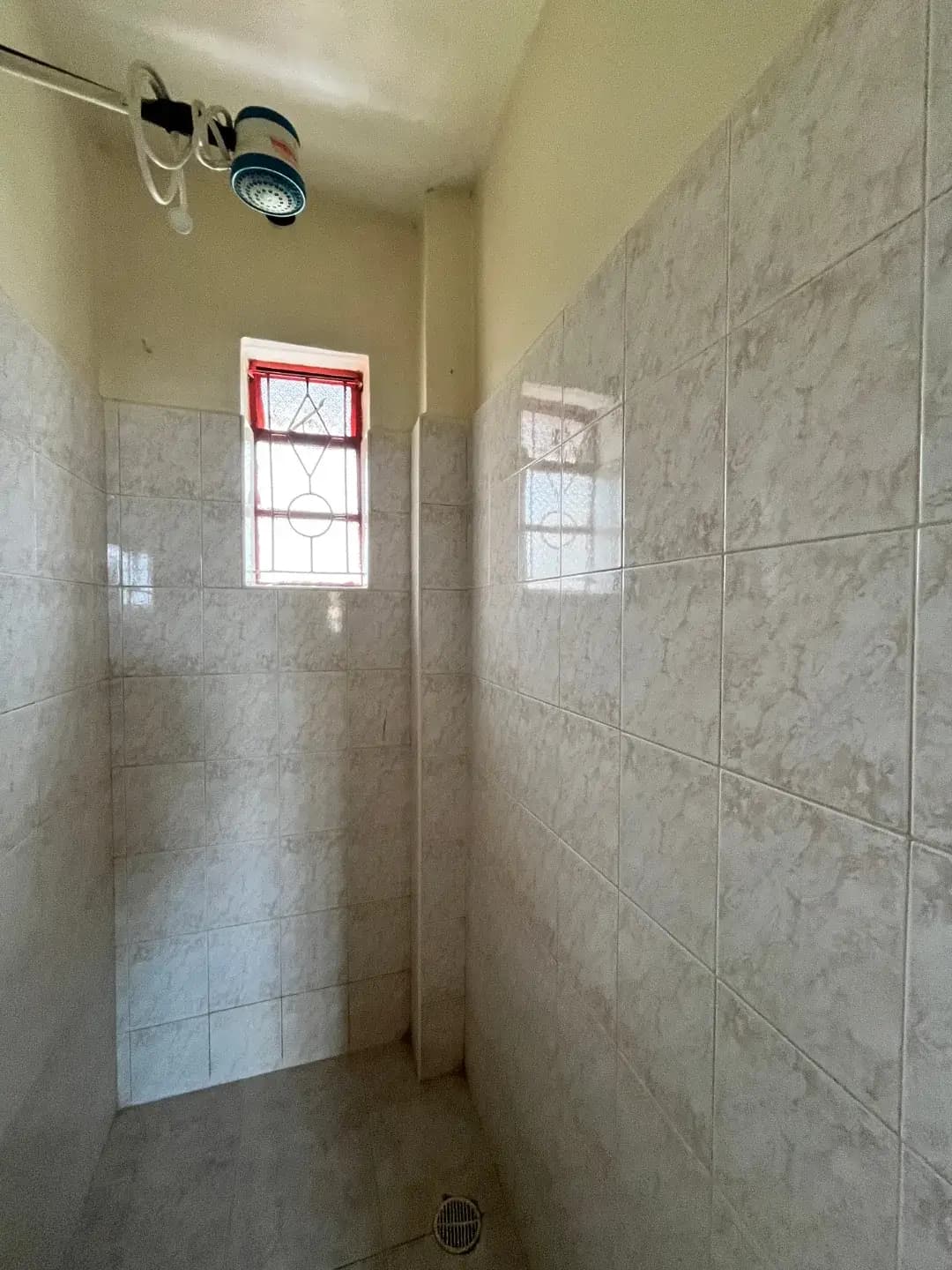 Narrow bathroom with tiled walls and small windows