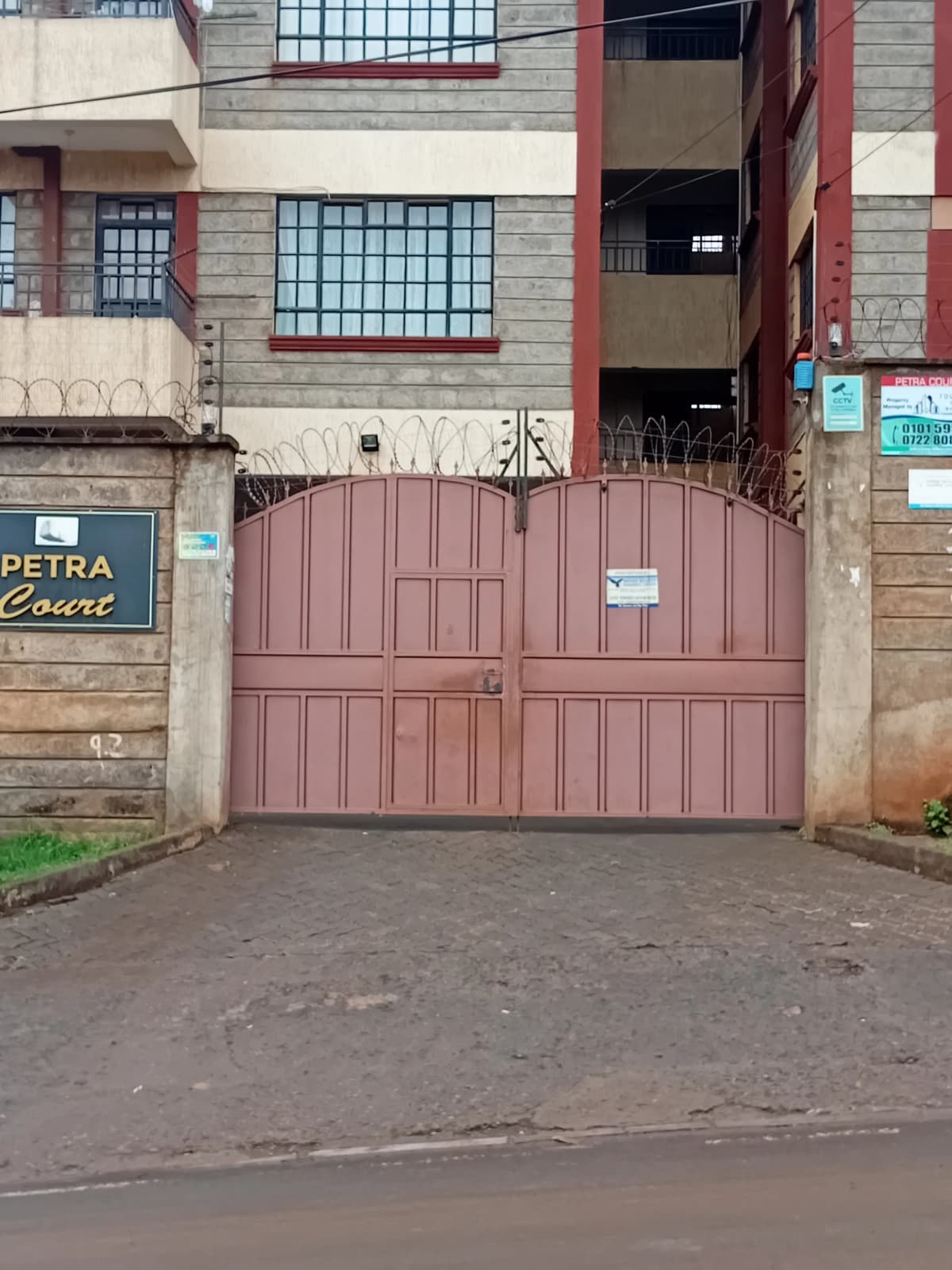 Compound entrance with maroon metal double gates