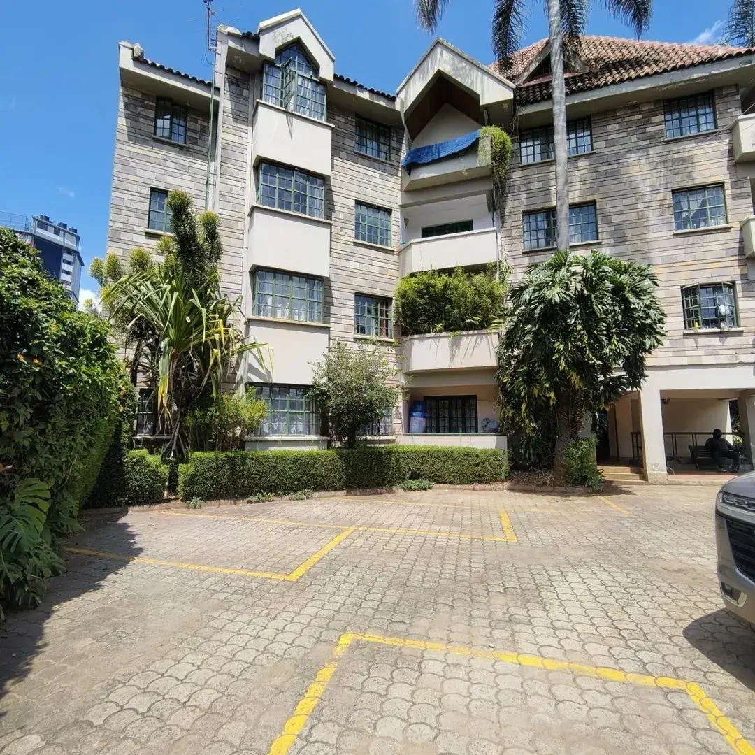 Multi-story residential building with paved compound entrance