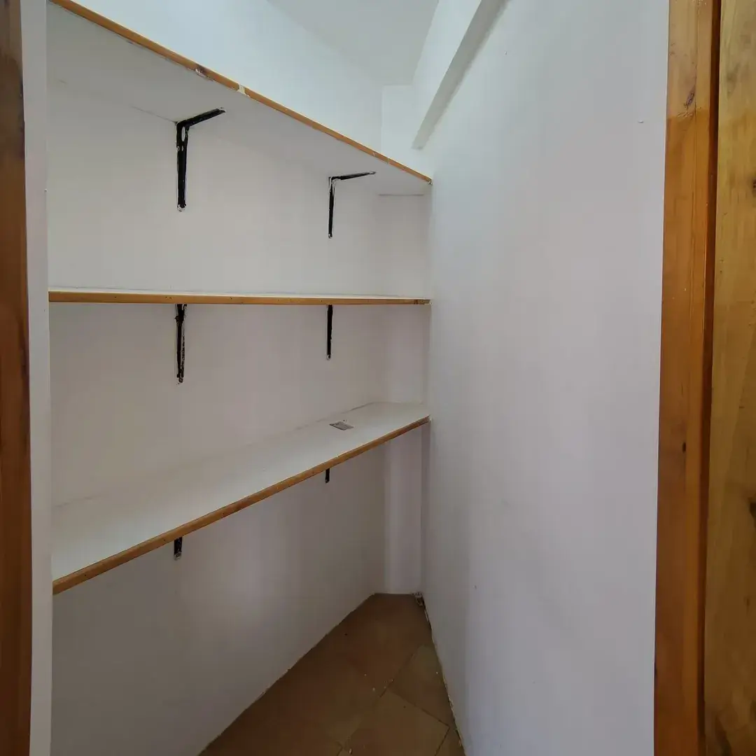 Empty pantry with wooden shelves and black brackets