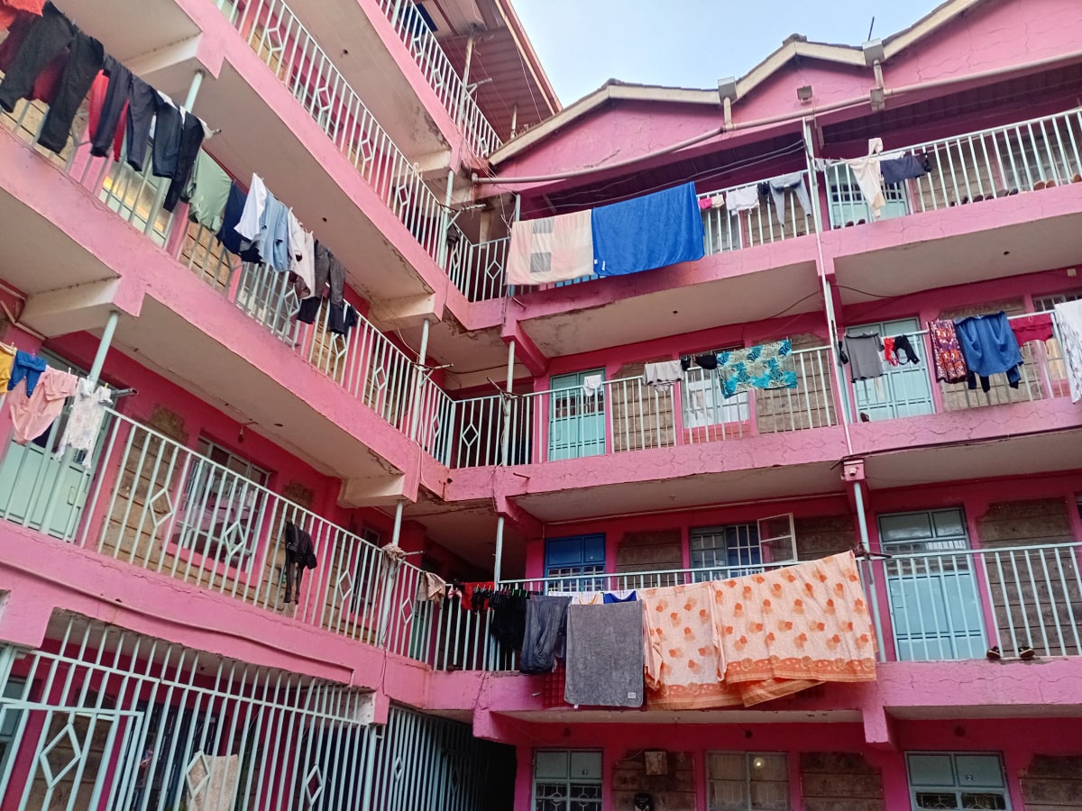 Pink residential apartment building facade with multiple balconies