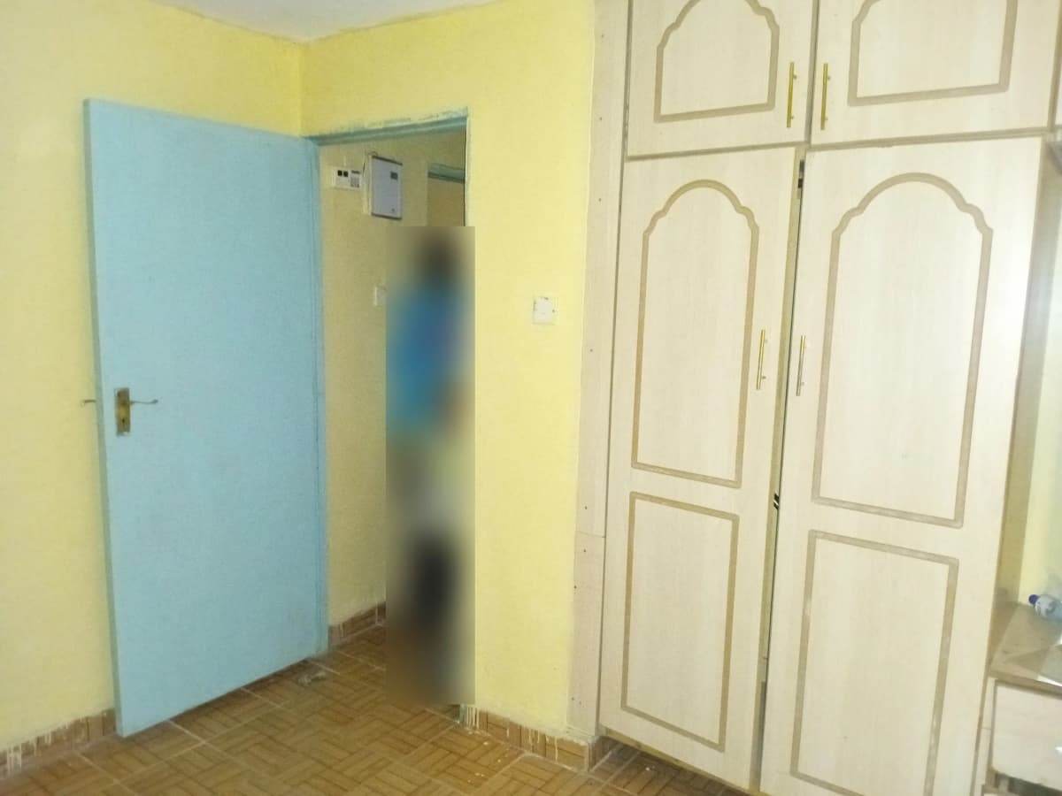 Modest bedroom with blue door and built-in wardrobes