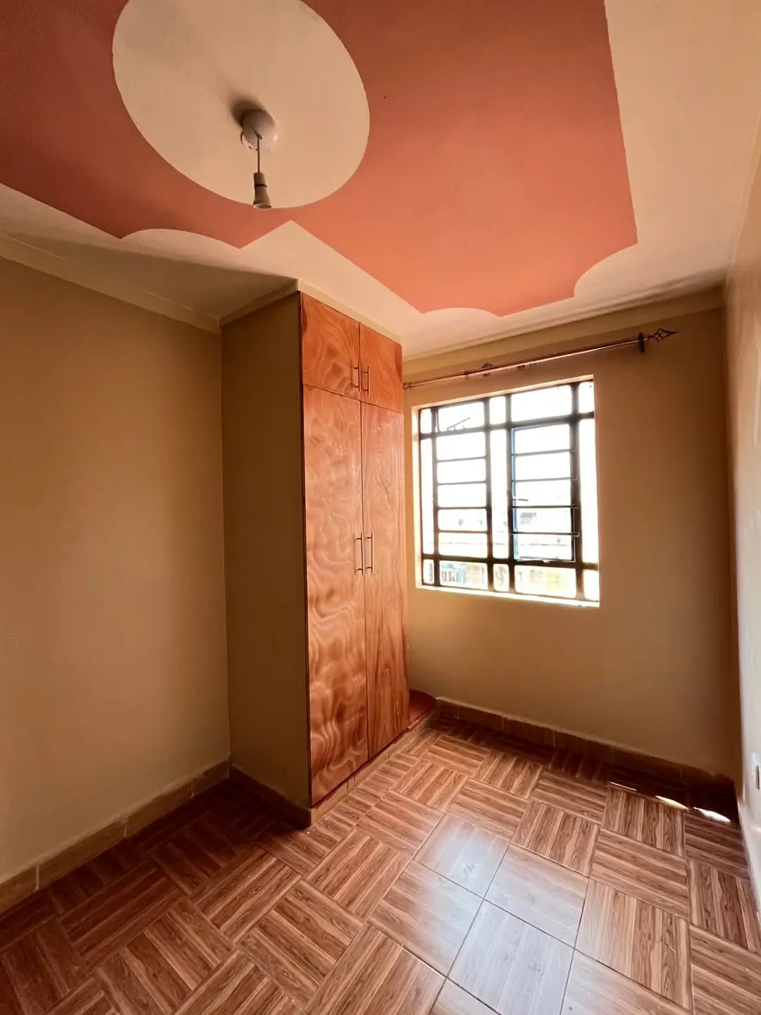 Bedroom with wooden wardrobe, herringbone floor, colored ceiling