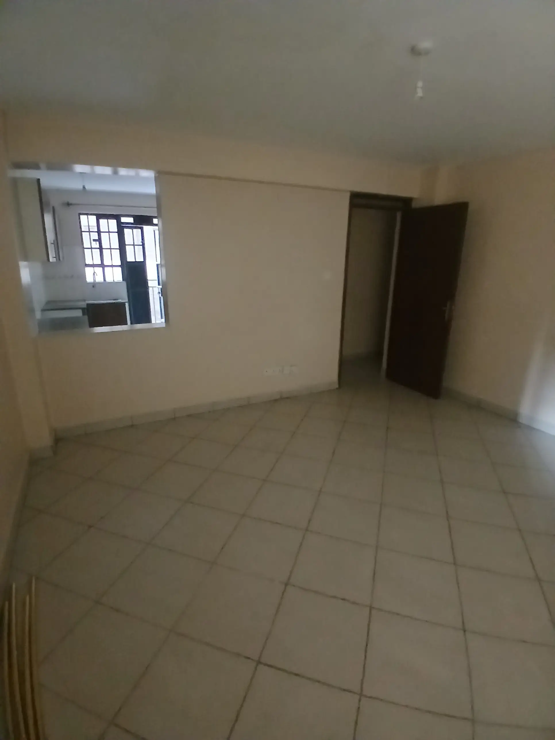 Empty living room with tiled floor and natural light