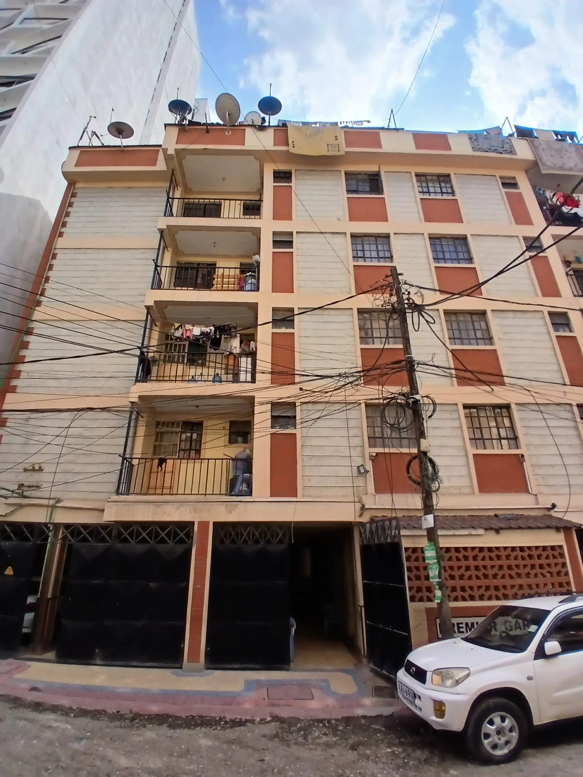 Multi-story residential building facade with balconies and parking