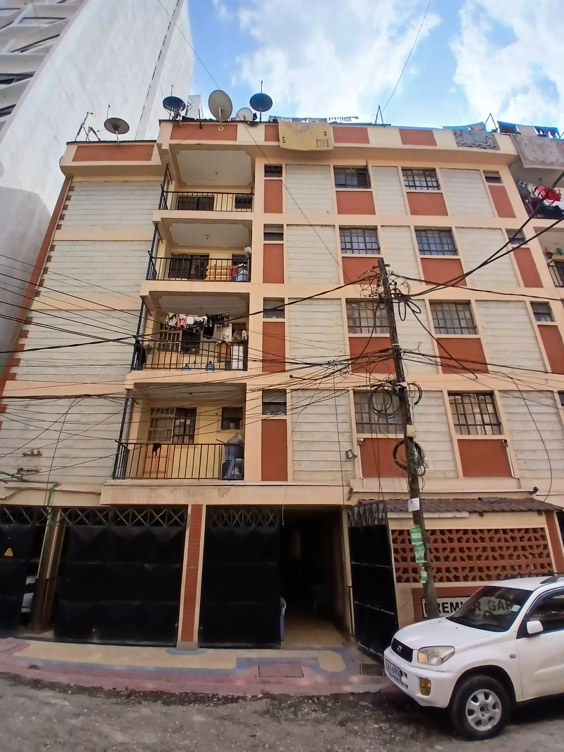 Multi-story residential building facade with balconies and parking