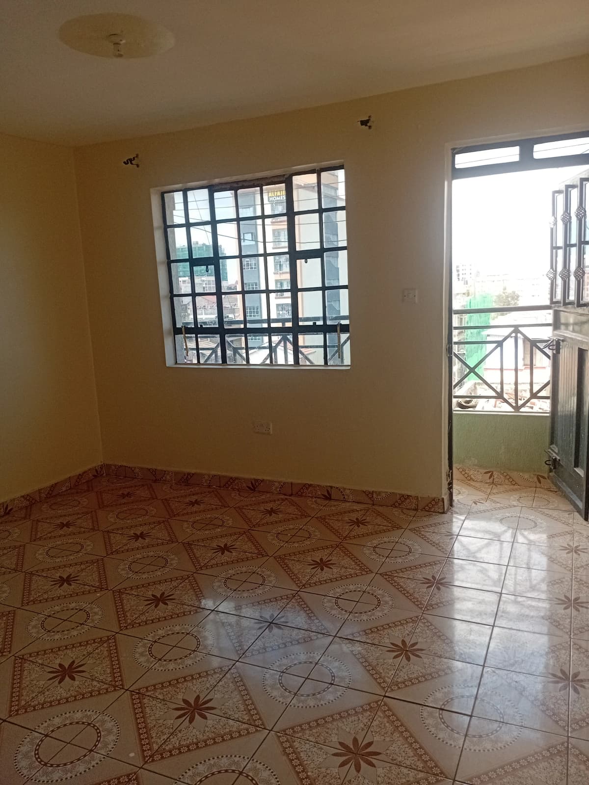 Spacious living room with decorative tile floor and balcony access
