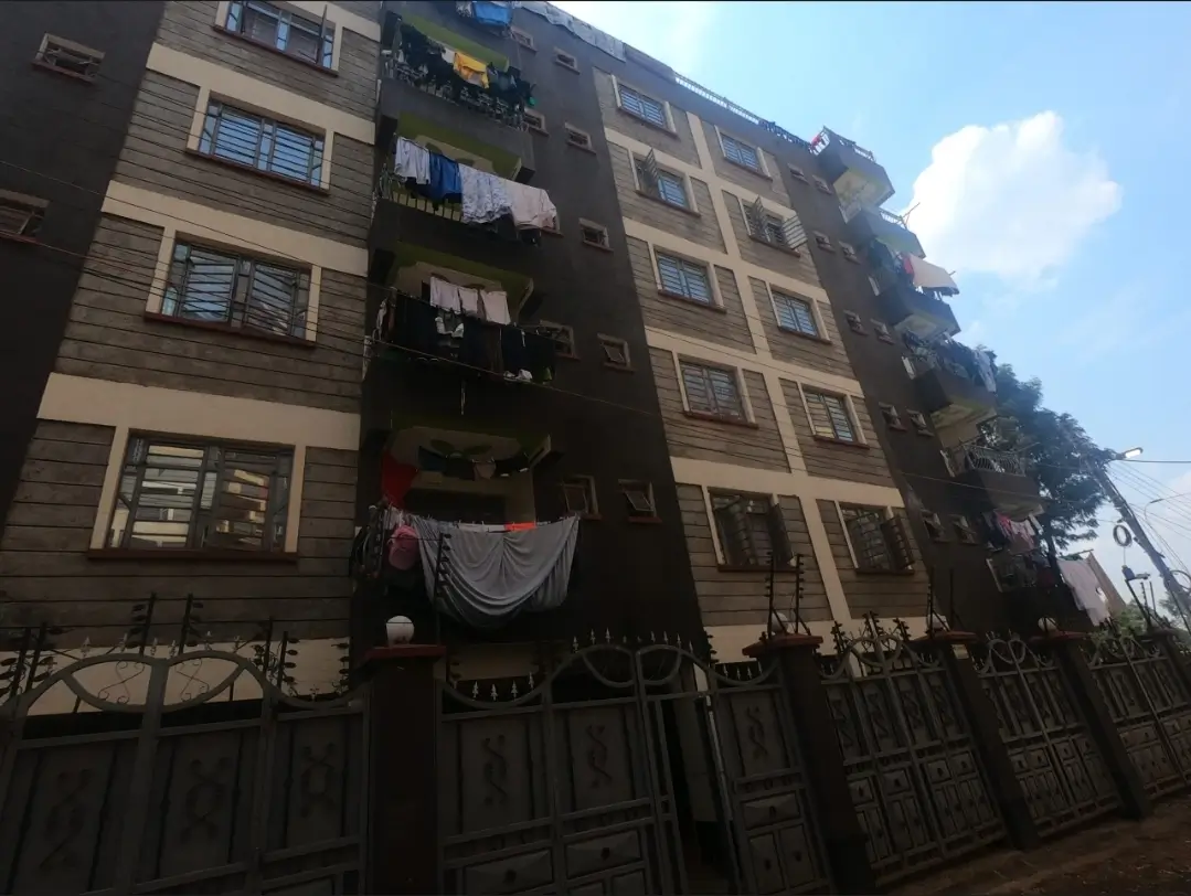 Multi-story residential building facade with metal gate entrance