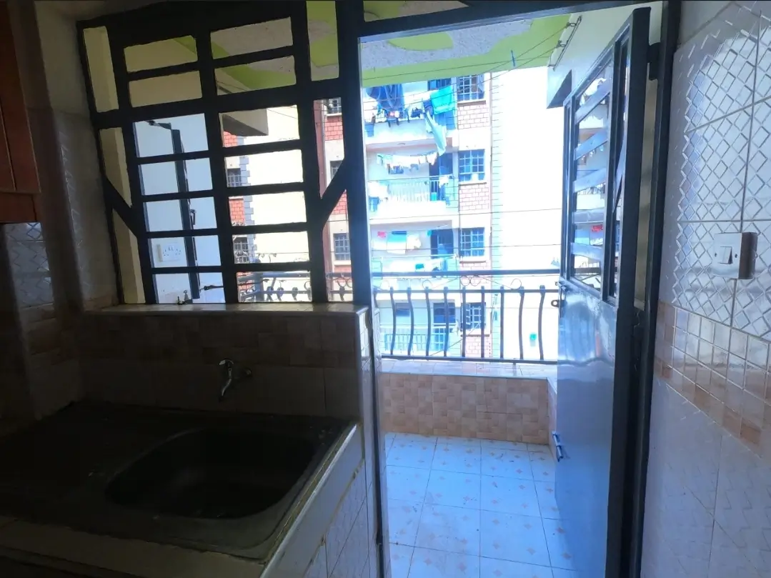 Balcony with blue-tiled flooring overlooking residential compound