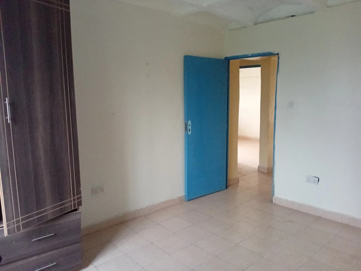 Empty bedroom with blue door and tiled flooring