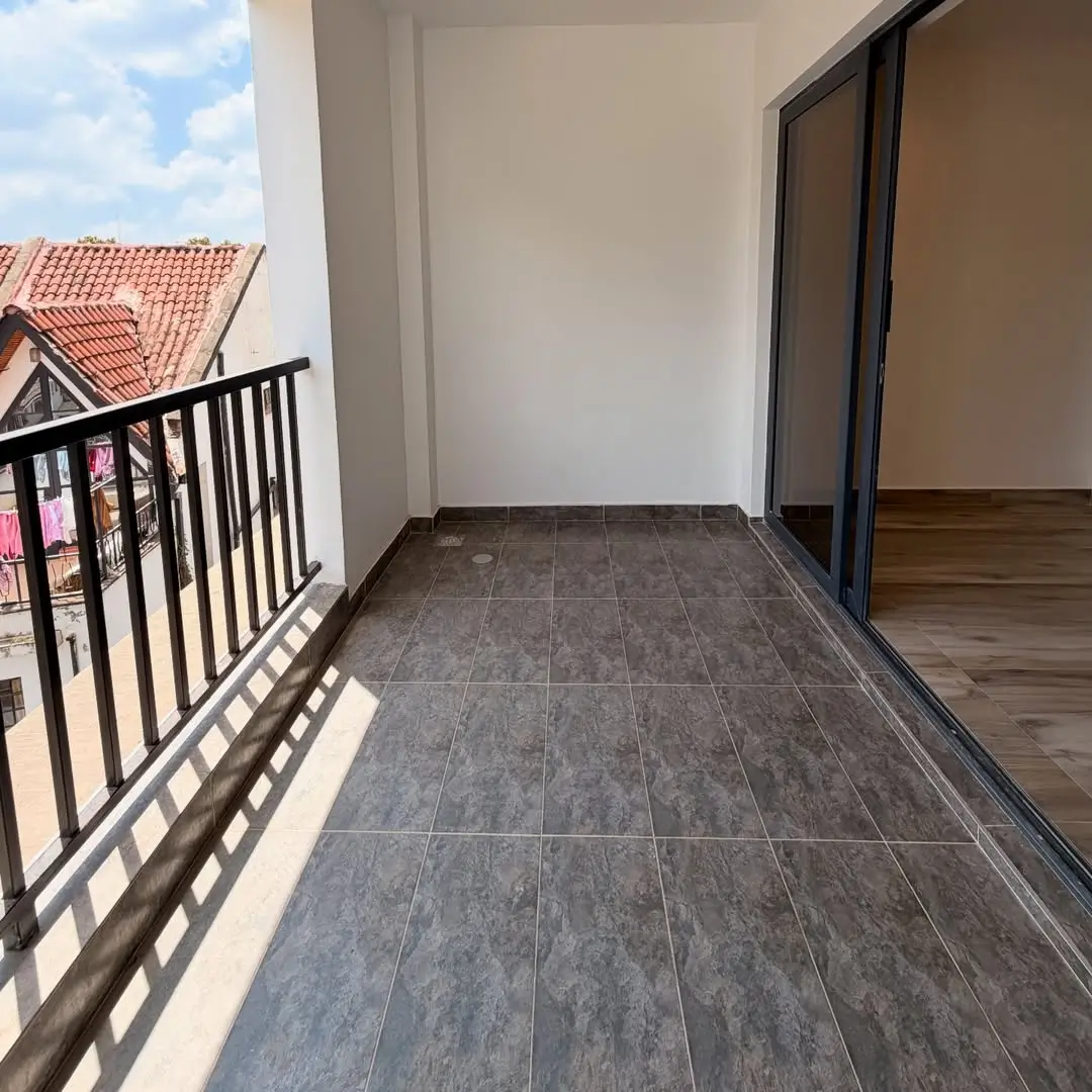 Spacious balcony with gray tile flooring and black railings