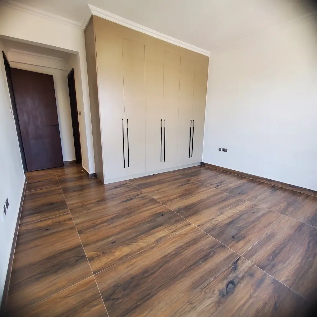Spacious bedroom with built-in wardrobe and wooden flooring