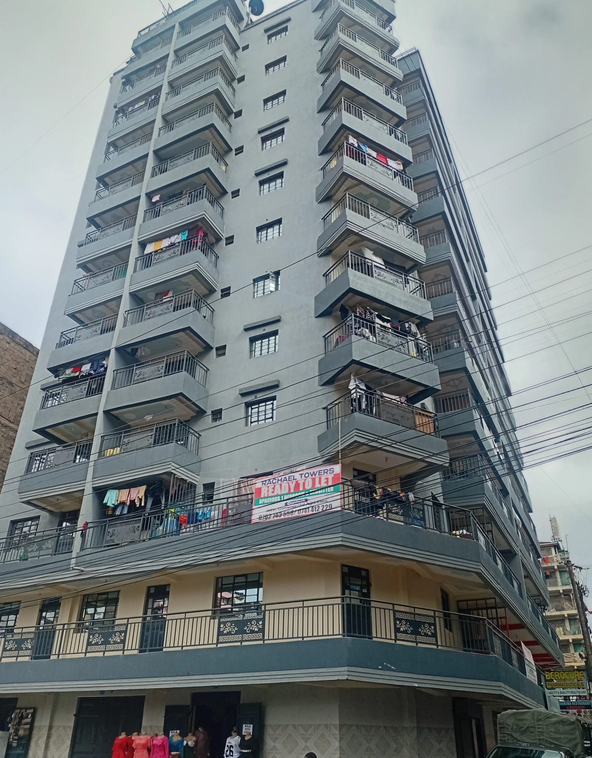 Multi-story residential building with balconies and ground-floor commercial