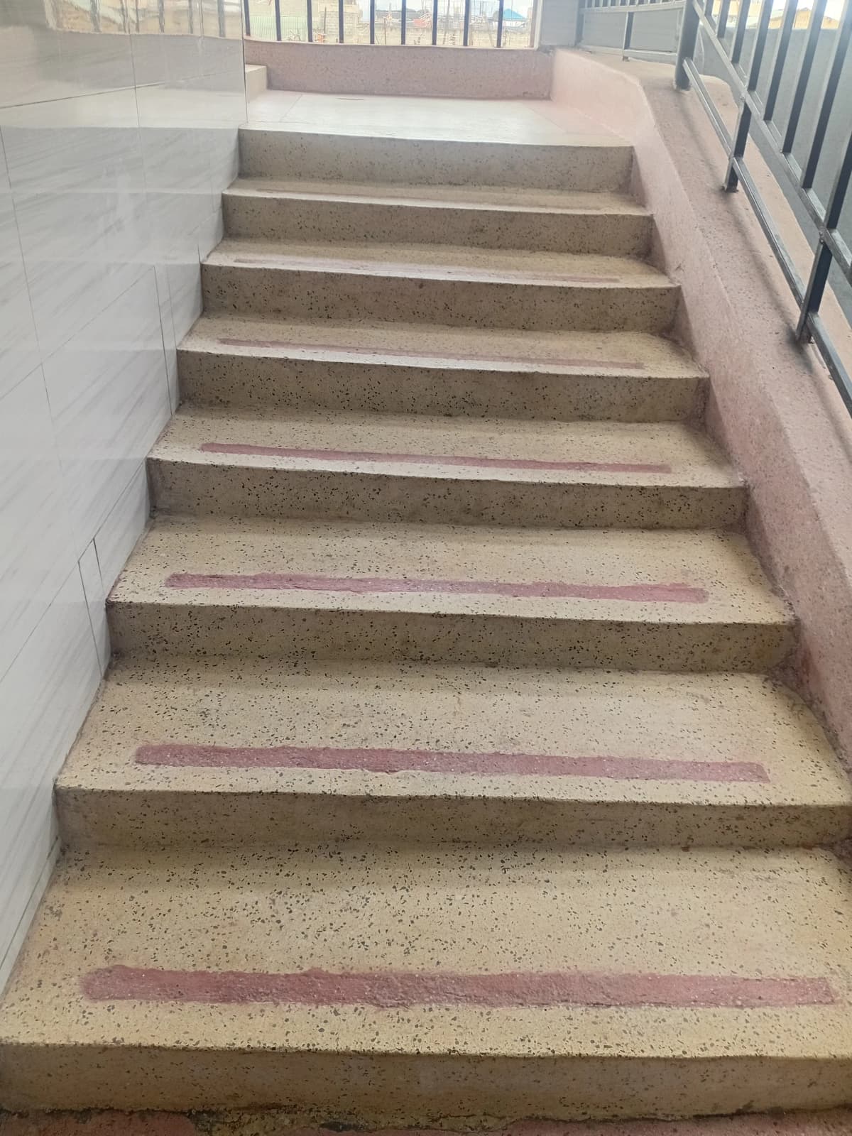 Interior staircase with concrete steps and metal railing