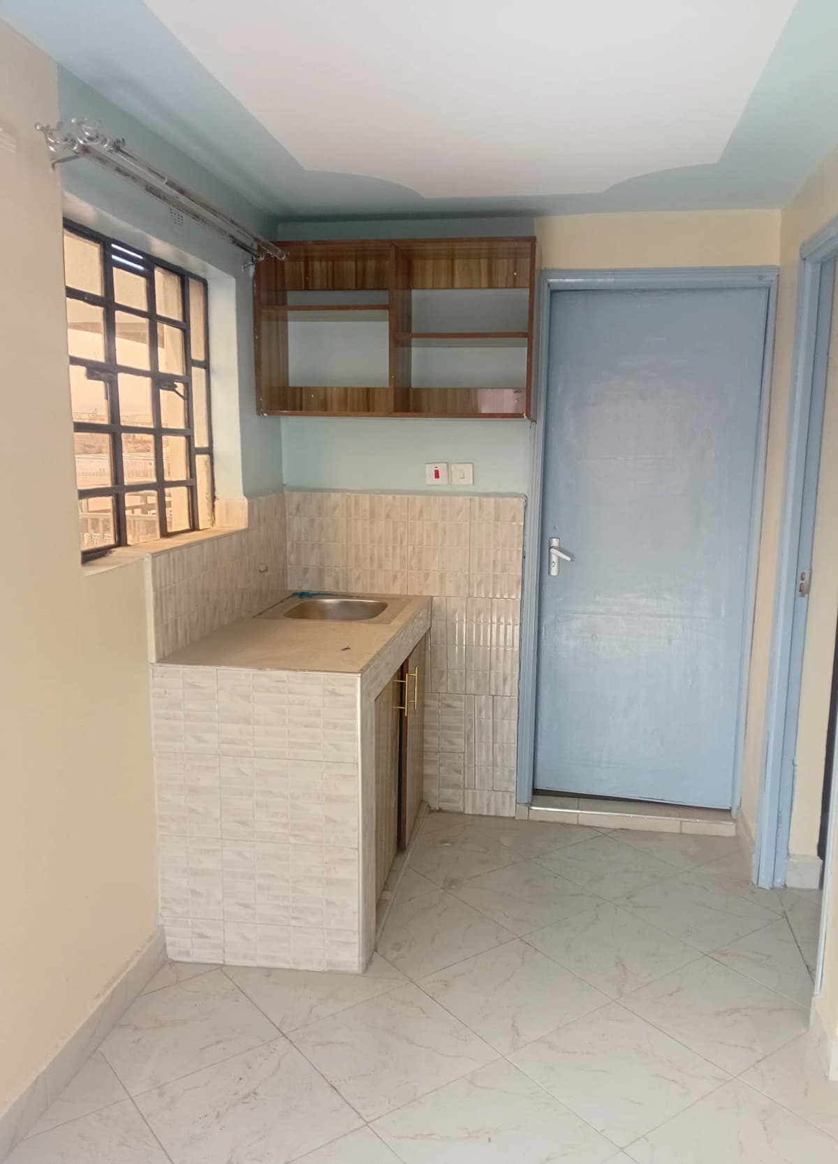 Compact kitchen with wooden cabinets and small countertop
