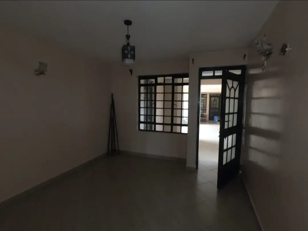 Empty living room with grid-pattern doors and natural light