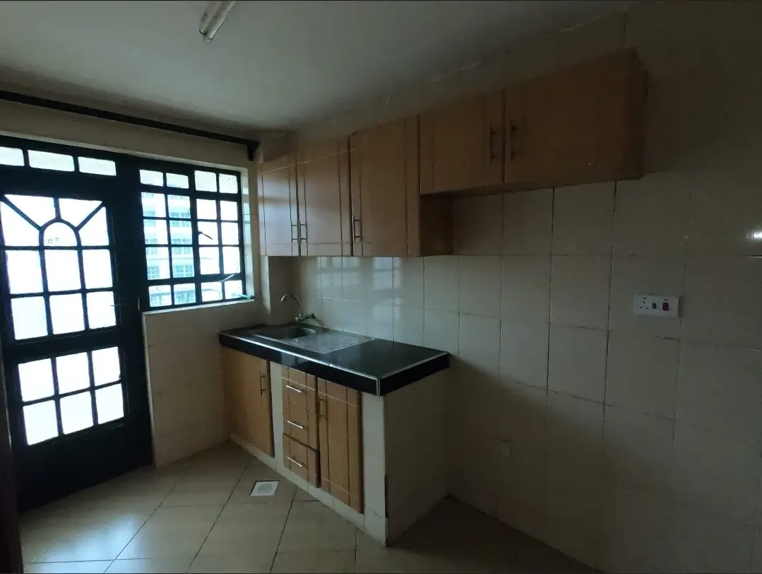 Compact kitchen with wooden cabinets and black countertop