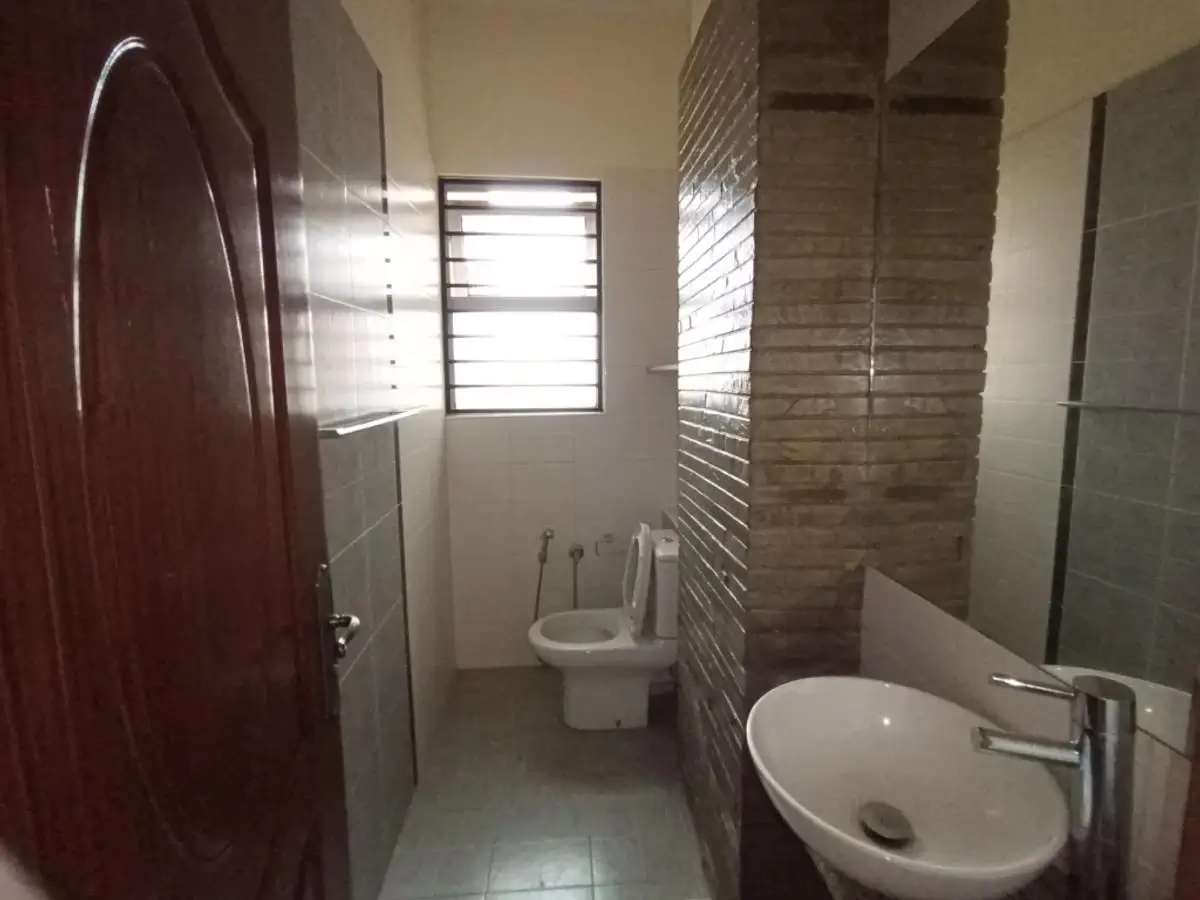 Compact bathroom with sink, toilet, and shower enclosure
