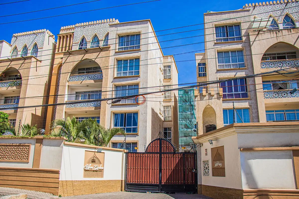 Multi-story residential building with ornate facade and gated entrance