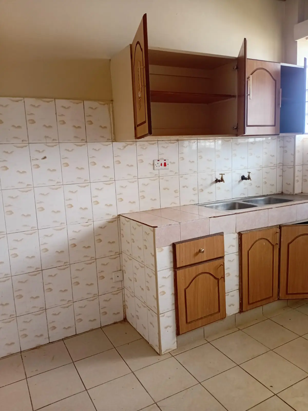 Compact kitchen with tile backsplash, wooden cabinets, and sink