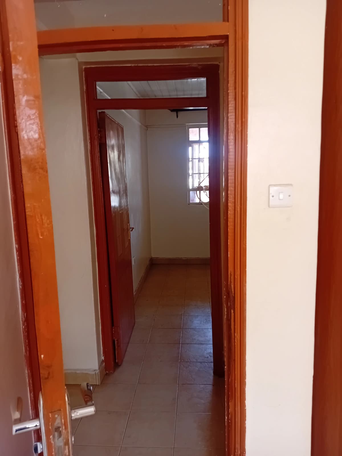 Interior hallway with wooden doors and terracotta tile flooring