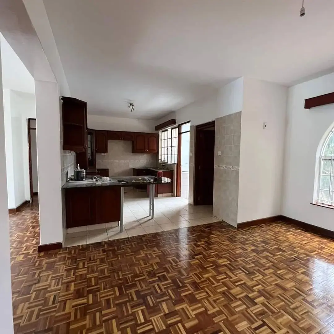 Open-plan living space with integrated kitchen, geometric wood flooring