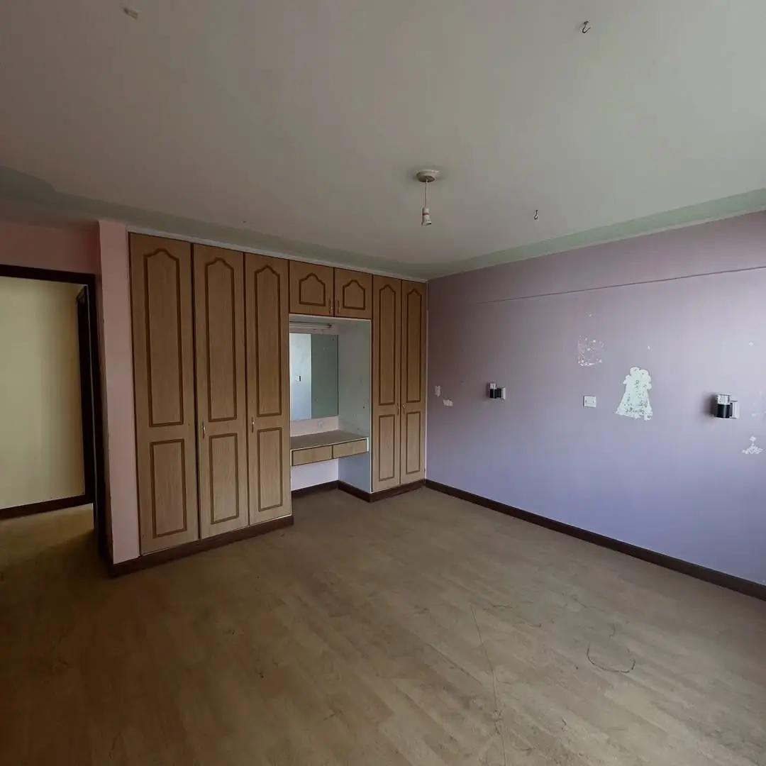 Empty bedroom with wooden wardrobe and lavender accent wall