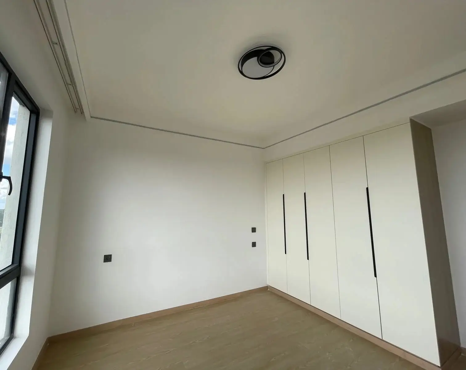 Minimalist bedroom with built-in wardrobes and window
