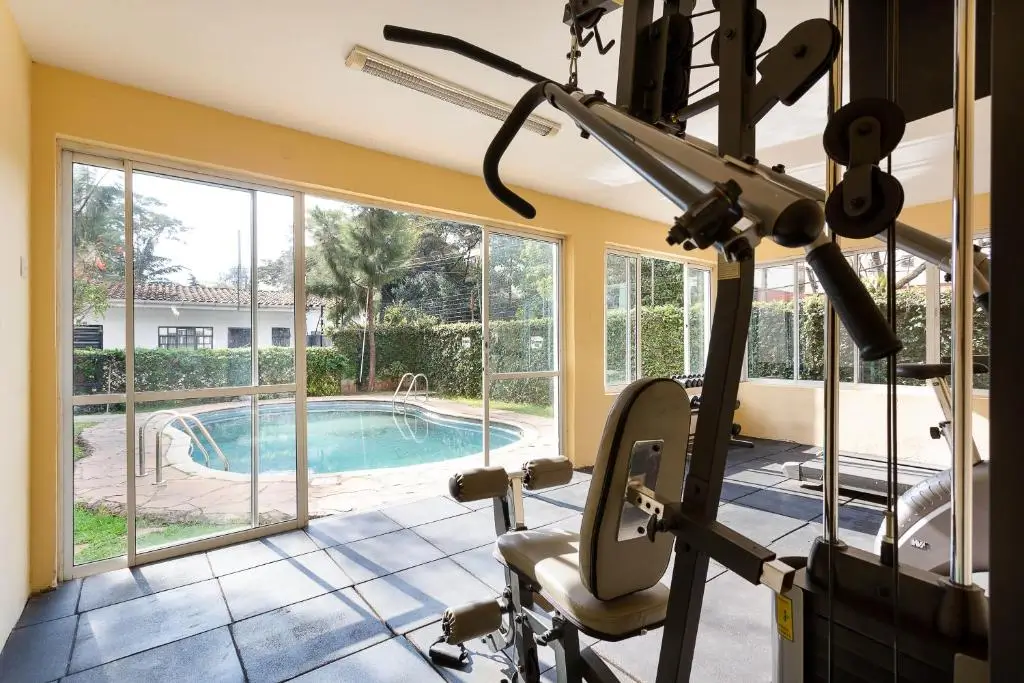 Home gym with stationary bike overlooking pool area
