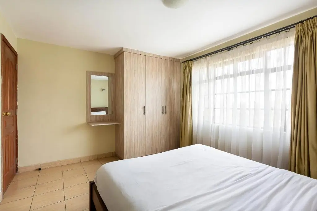 Master bedroom with built-in wardrobe and large windows