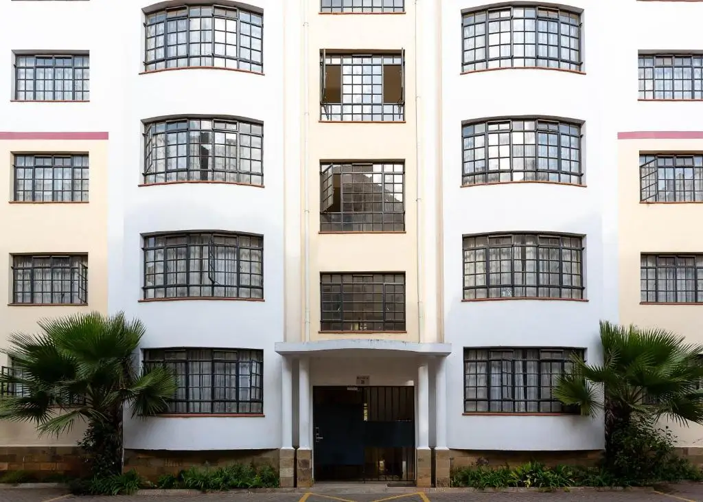 White multi-story building facade with curved balconies and entry