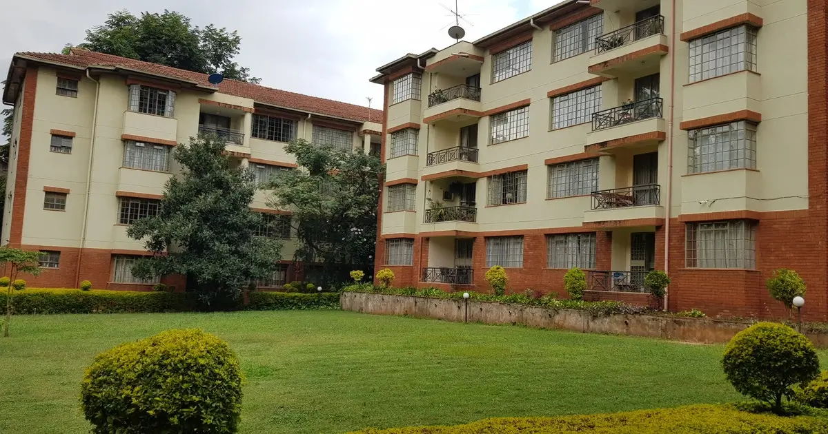 Multi-story residential building with manicured compound grounds