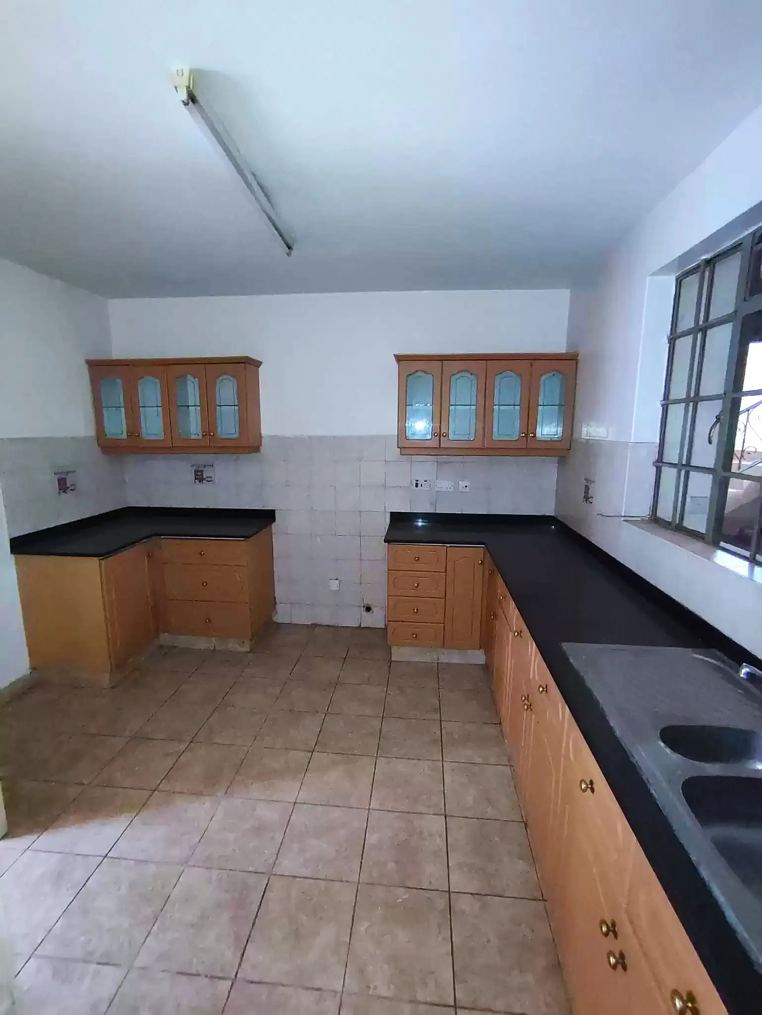 Spacious kitchen with wooden cabinets and black countertops