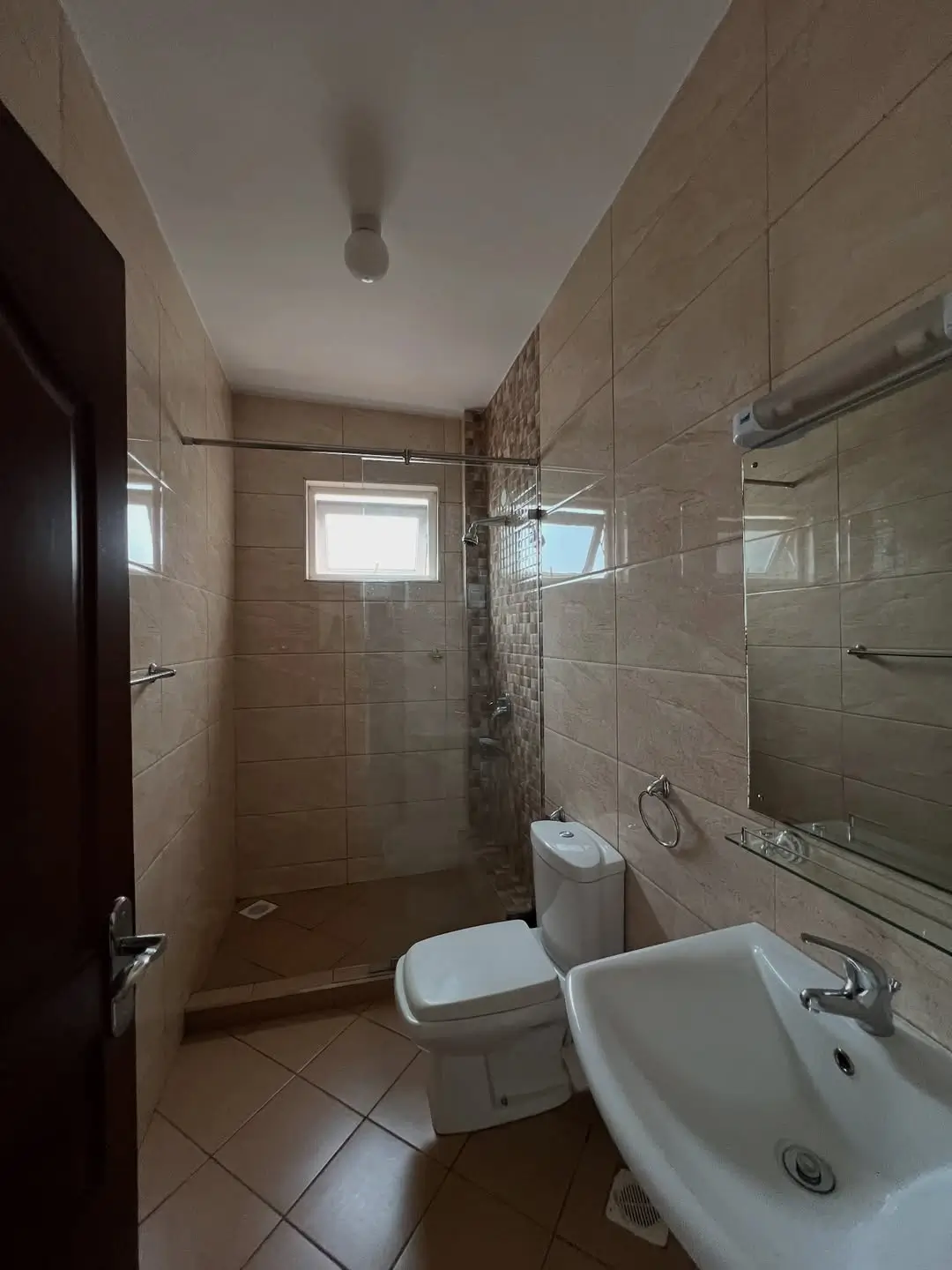 Modern bathroom with walk-in shower, toilet, and pedestal sink