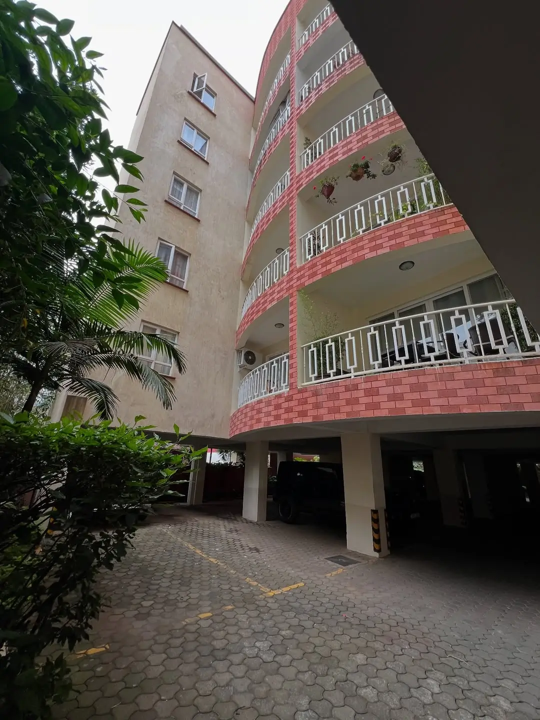 Multi-story residential building with red brick facade and balconies