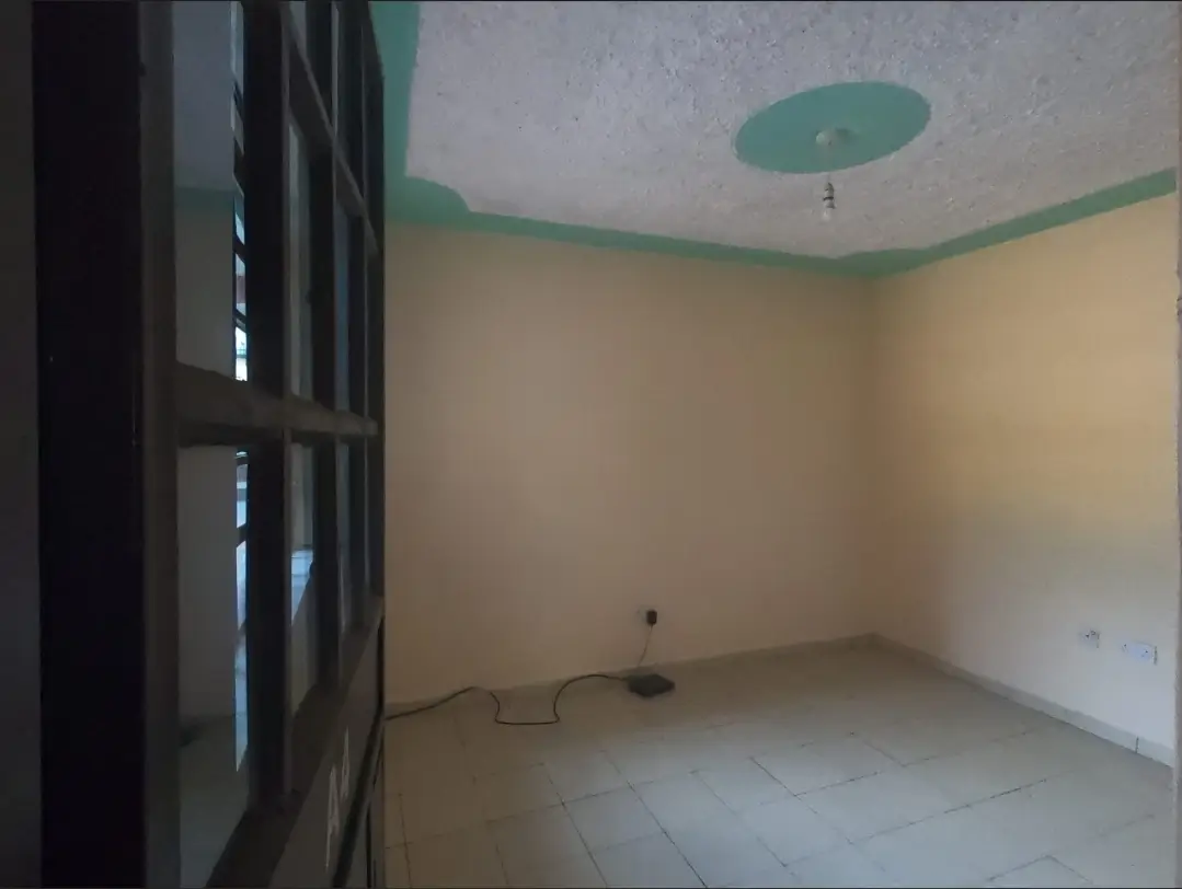 Empty living room with green ceiling accents and tiled floor