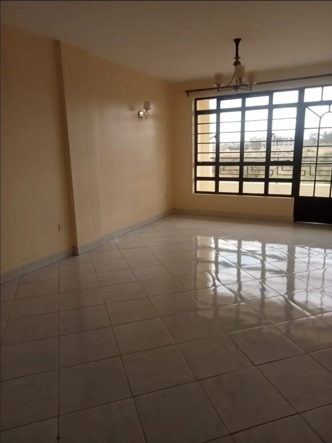 Spacious living room with polished tile flooring and large windows