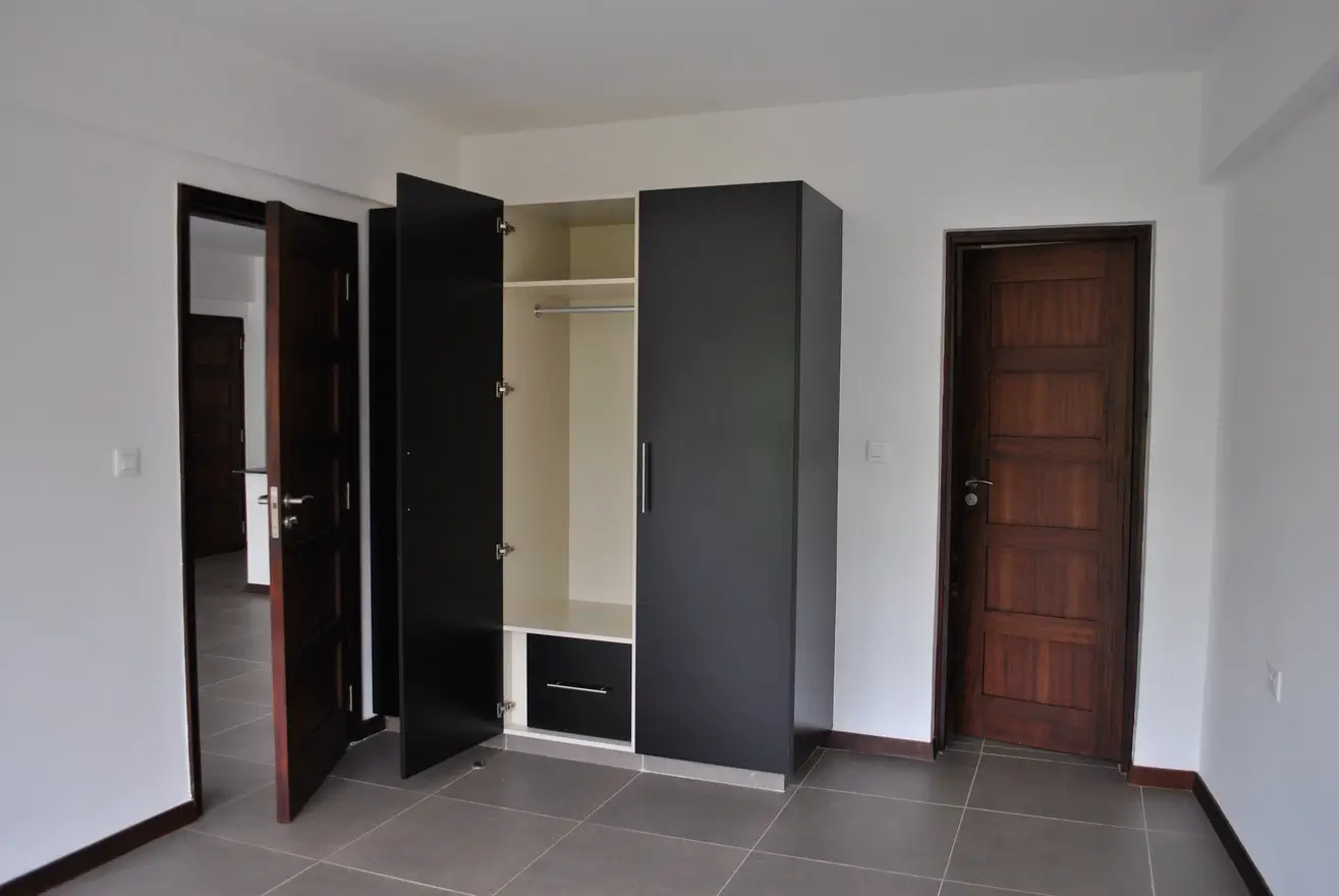 Spacious bedroom with built-in wardrobes and multiple doors