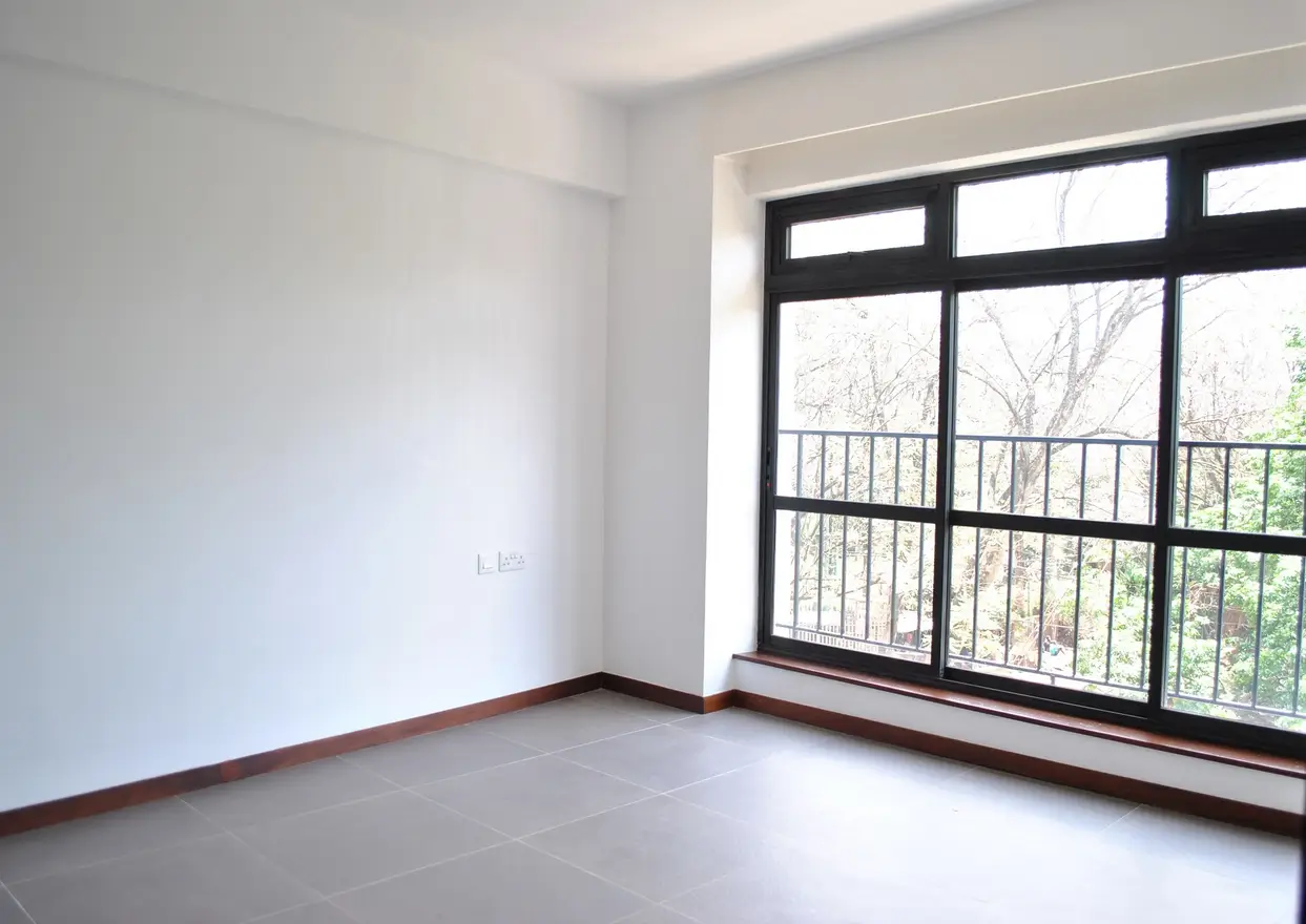 Spacious bright bedroom with large window and balcony access