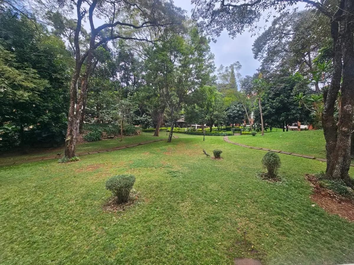 Spacious landscaped grounds with mature trees and manicured lawn