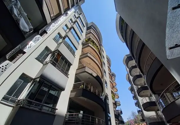 Modern multi-story residential building facade with curved balconies