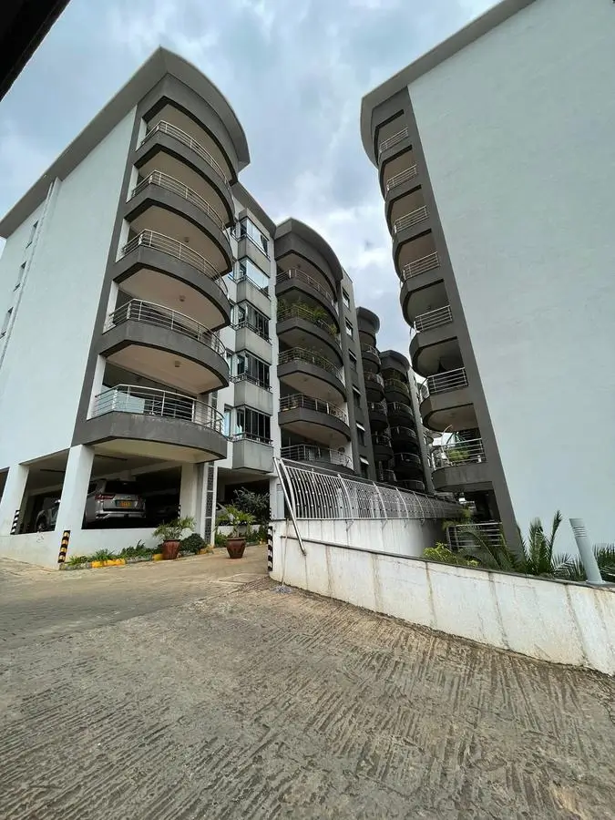 Modern multi-story residential building with curved balconies and parking