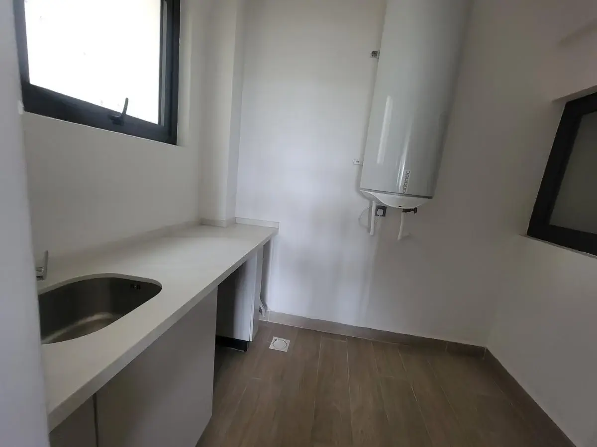 Utility room with sink, water heater, wooden flooring