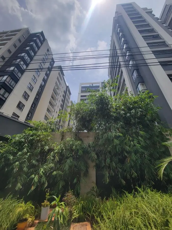 Lush compound garden with tropical plants and apartment buildings