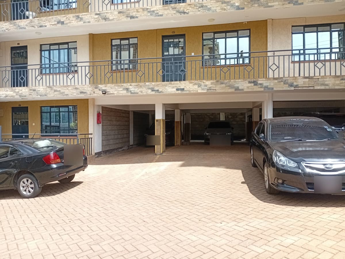 Ground-floor parking area with two vehicles and building facade